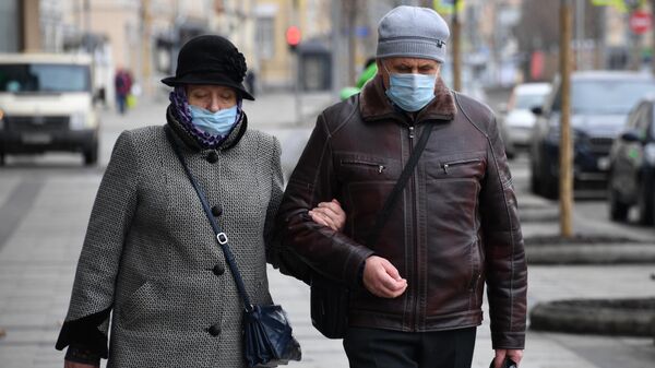 Прохожие в защитных масках на улице в Москве