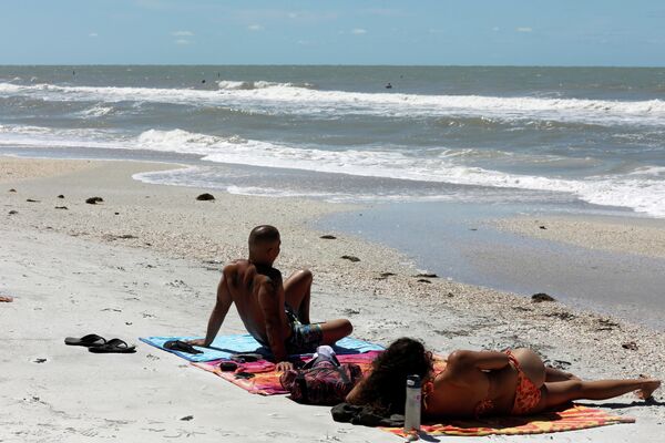 Люди отдыхают на пляже Трежер-Айленда в округе Пинеллас, несмотря на его закрытие из-за коронавируса
