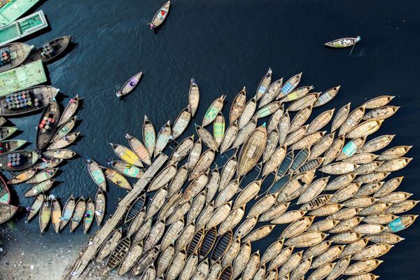 Лодочники ожидающие пассажиров на берегу реки в Дакке, Бангладеш
