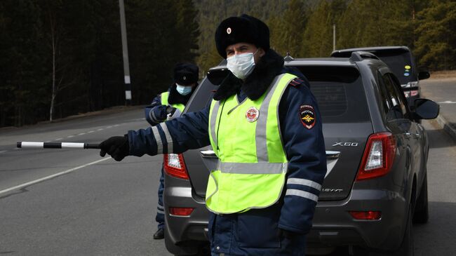 Сотрудник ДПС останавливает автомобиль для проверки