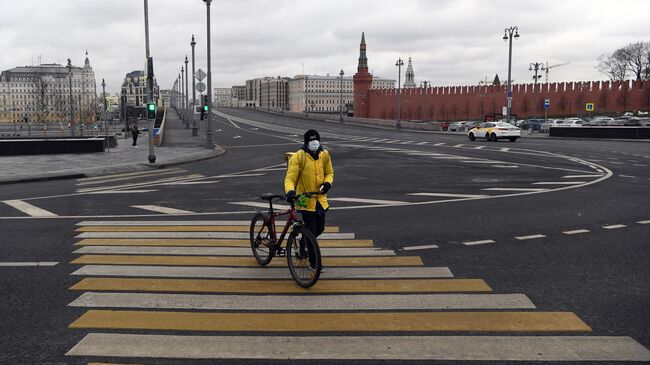 Сотрудник службы доставки  на пешеходном переходе