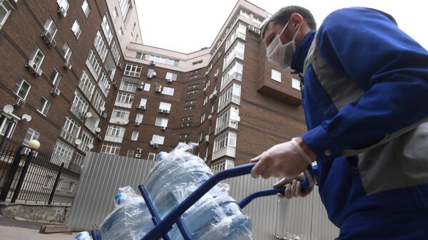 Сотрудник службы доставки воды доставляет заказ по адресу в Москве
