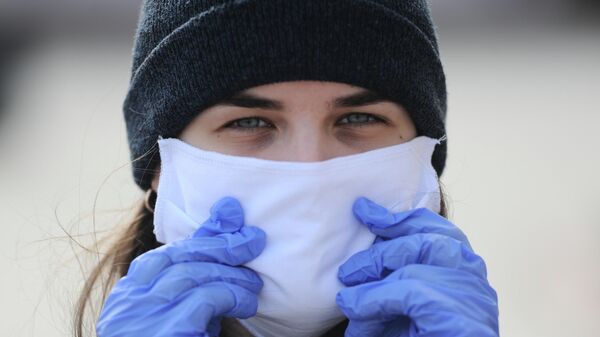 Сотрудница волонтерского центра в защитной маске и перчатках