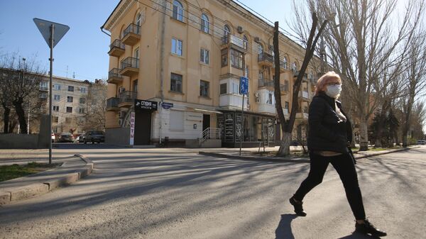 Женщина в медицинской маске на одной из улиц в Волгограде