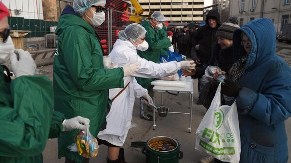 Волонтеры благотворительного фонда имени Елизаветы Глинки Доктор Лиза раздают еду бездомным в районе Ярославского вокзала