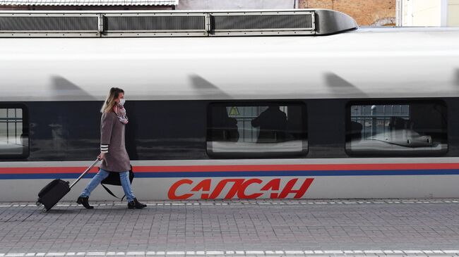 Пассажир у поезда Сапсан на Ленинградском вокзале в Москве