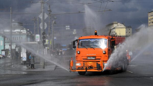 Распылительная и поливомоечная техника во время дезинфекции проезжей части в Москве