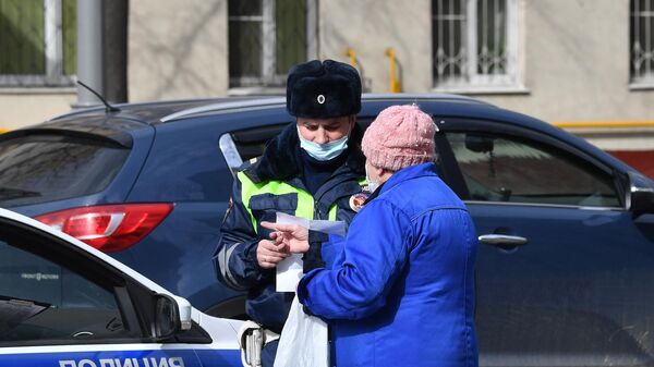 Сотрудник полиции общается с жительницей Москвы в дни режима самоизоляции граждан в связи с распространением коронавируса