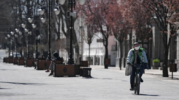 Велосипедист в защитной маске на улице Пушкина в Симферополе