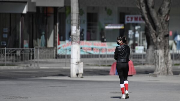 Девушка в защитной маске на улице в Симферополе