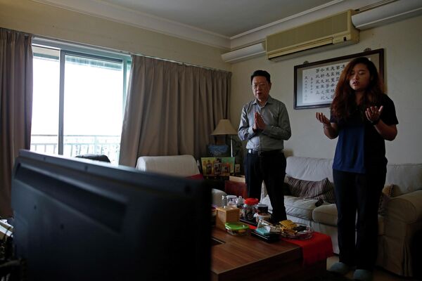 Люди принимают участие в онлайн-мессе у себя дома в Гонконге, Китай