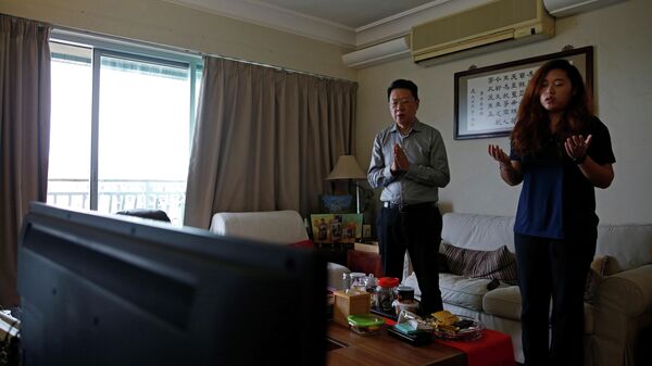 Люди принимают участие в онлайн-мессе у себя дома в Гонконге, Китай