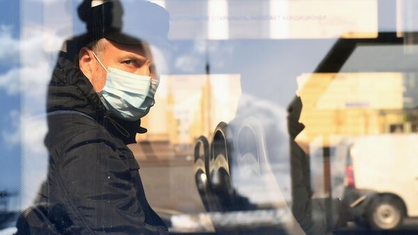 Пассажир в медицинской маске в салоне автобуса на одной из улиц Москвы