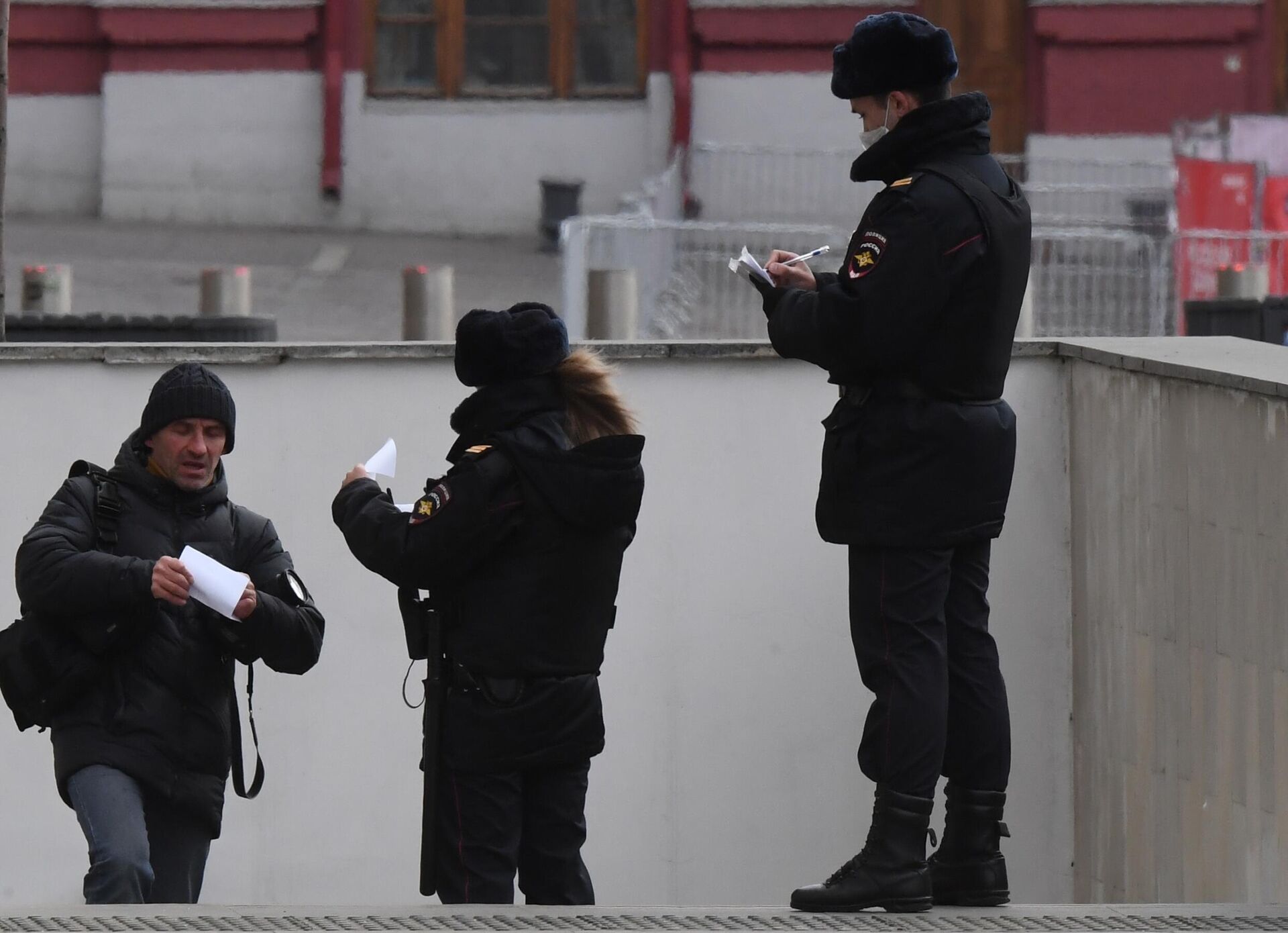 Сотрудники полиции проверяет документы у мужчины в Москве - РИА Новости, 1920, 26.11.2021