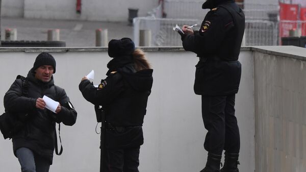 Сотрудники полиции проверяет документы у мужчины в Москве