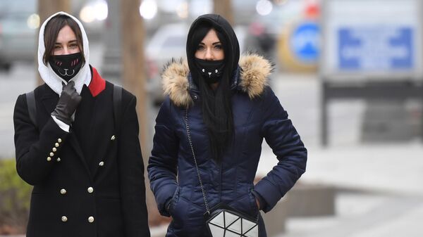 Девушки в медицинских масках на одной из улиц Москвы