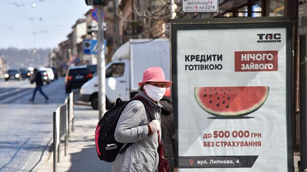 Женщина в защитной маске на одной из улиц во Львове