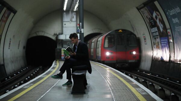 Мужчина читает книгу в Лондонской подземке во время эпидемии коронавируса