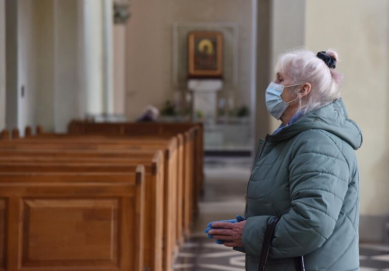 Женщина в защитной маске в одном из храмов во Львове