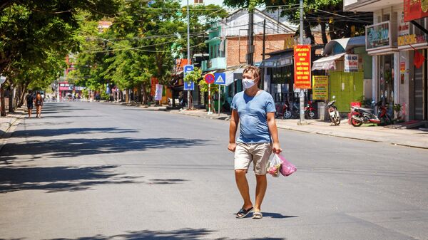 Турист в защитной маске в курортном городе Нячанг во Вьетнаме