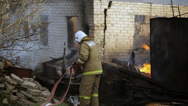 Сотрудник МЧС во время тушения пожара в Тракторозаводском районе Волгограда