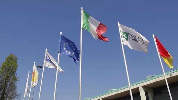 Флаги у полевого госпиталя в Бергамо, в котором российские и итальянские специалисты в круглосуточном режиме будут принимать, диагностировать и лечить заболевших коронавирусом COVID-19