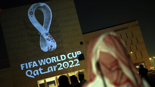 People gather at the capital Doha's traditional Souq Waqif market while the official logo of the FIFA World Cup Qatar 2022 is projected on the front of a building on September 3, 2019. (Photo by - / AFP)