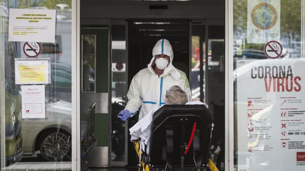 Медицинской работник доставляет пациента на каталке в приемное отделение госпиталя Северо Очоа в Мадриде