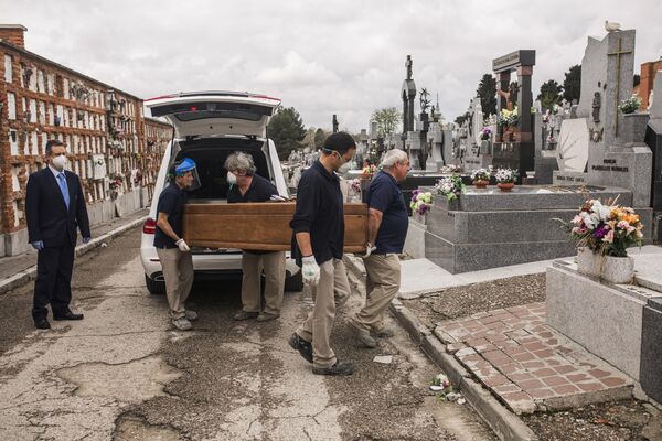 Грузчики несут гроб на кладбище Альмудена в Мадриде