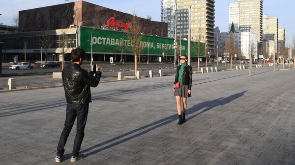 Молодые люди фотографируются на улице Новый Арбат в Москве