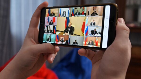 Житель Москвы смотрит трансляцию совещания президента РФ Владимира Путина с руководителями субъектов РФ