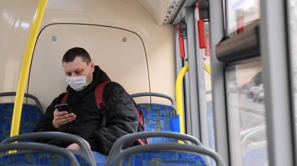Мужчина в медицинской маске в салоне городского автобуса в Москве