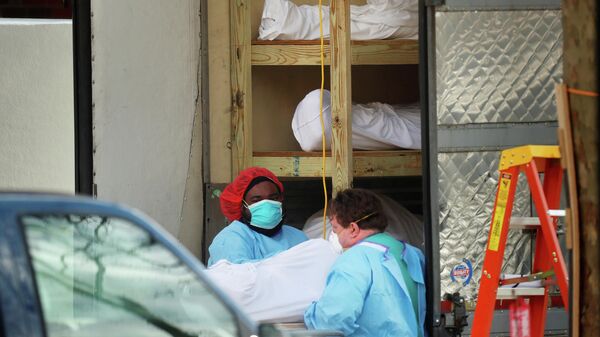Медицинские работники транспортируют тело умершего человека в медицинском центре в Бруклине, Нью-Йорк