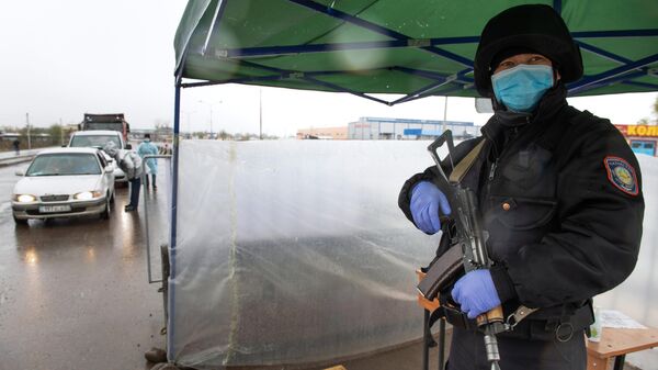 Сотрудник правоохранительных органов на блокпосте при въезде в Алма-Ату, где из-за распространения коронавируса введены ограничения на въезд и выезд из города
