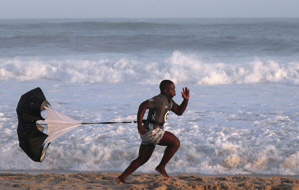 Мужчина тренируется на пляже Рекрейо-дос-Бандейрантес в Рио-де-Жанейро во время пандемии коронавируса