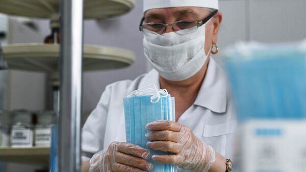 Сотрудница аптеки фасует одноразовые медицинские маски 
