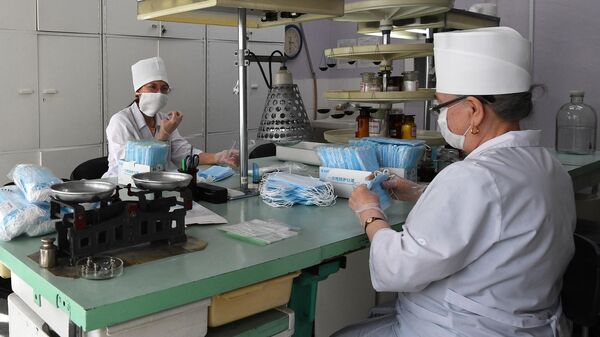 Сотрудницы аптеки в Новосибирске фасуют одноразовые медицинские маски в упаковки