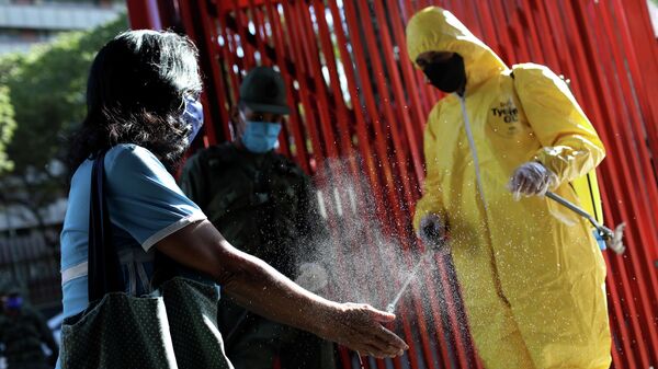 Дезинфекция рук при входе на рынок во время пандемии коронавируса в Каракасе