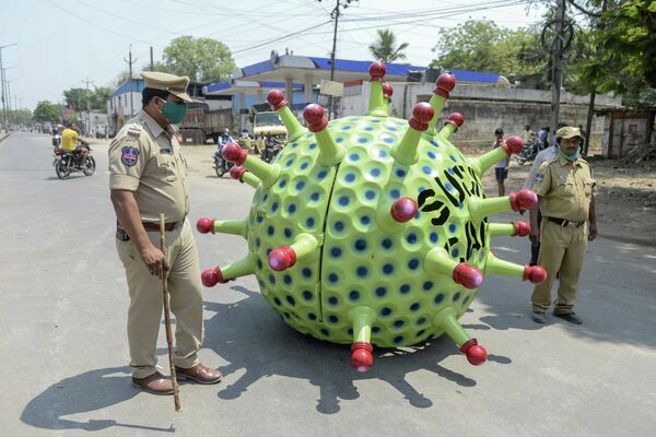 Полицейские возле автомобиля в виде коронавируса изобретателя Судхакара Ядава на улице Хайдарабада