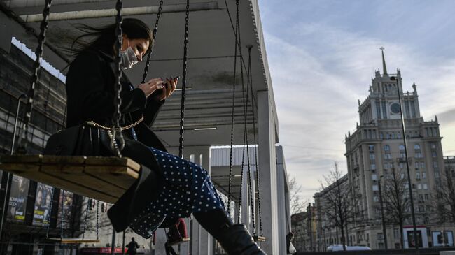 Девушка в защитной маске на Триумфальной площади в Москве