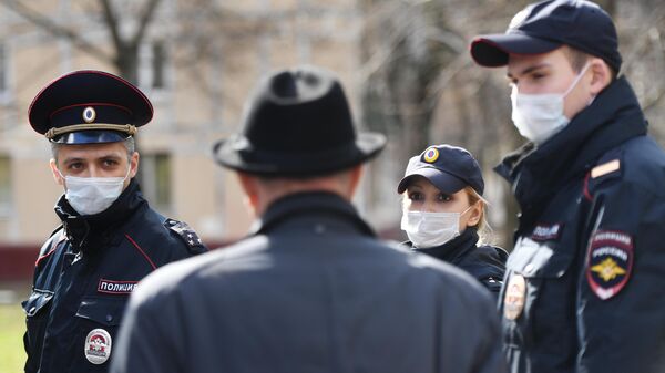 Сотрудники полиции разговаривают с пожилым мужчиной на улице Москвы