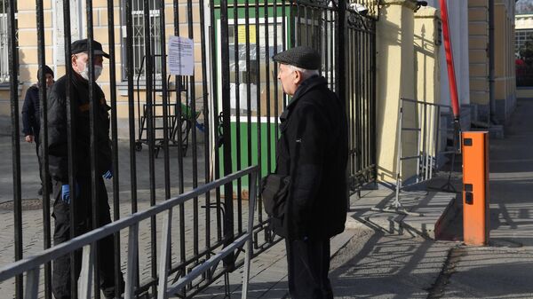 Мужчина читает объявление на воротах Ваганьковского кладбища в Москве