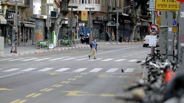 Мужчина переходит дорогу на одной из улиц Тель-Авива