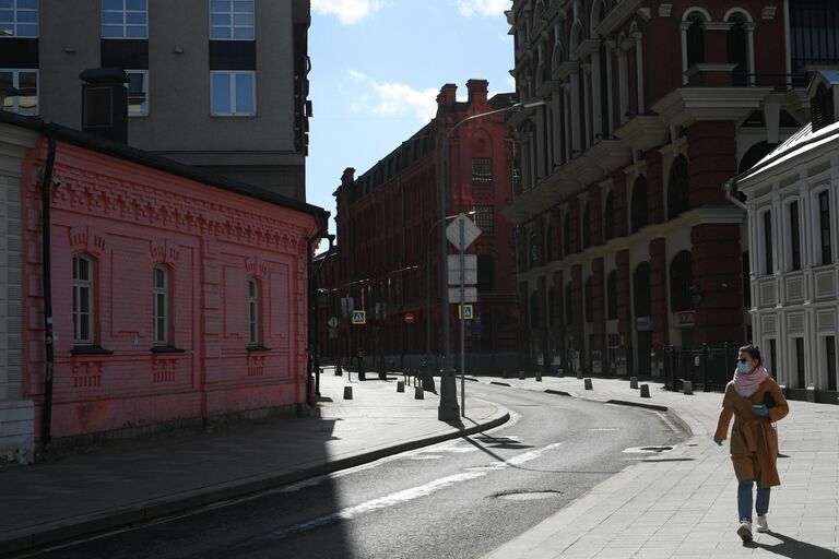 Женщина в маске на улице Большая Якиманка в Москве