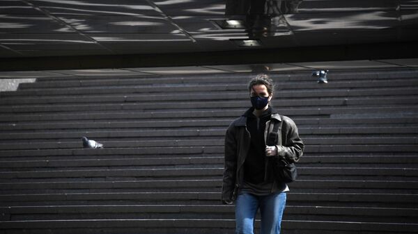 Девушка в защитной маске на одной из улиц Москвы