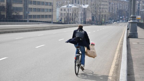 Велосипедист едет по улице в Москве