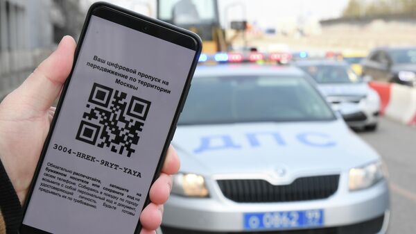 Житель Москвы демонстрирует цифровой пропуск для передвижения по городу