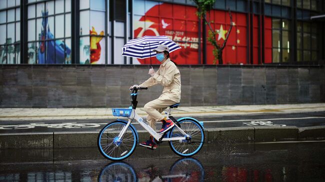 Женщина на велосипеде в Ухане, провинция Хубэй