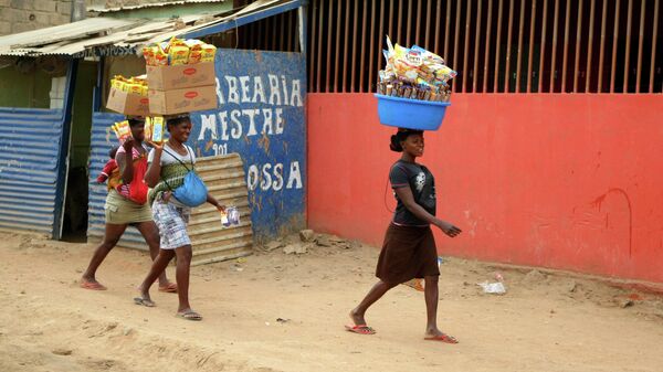 Женщины идут по одной из улиц города Луанда, Ангола 