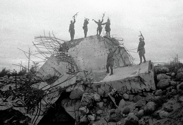Красноармейцы стоят на обломках одного из немецких дотов, взорванных советскими войсками